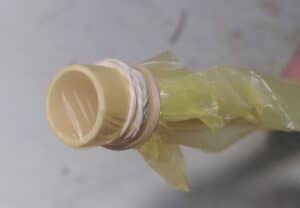 plastic folie met elastiekje om pvc buis gebonden